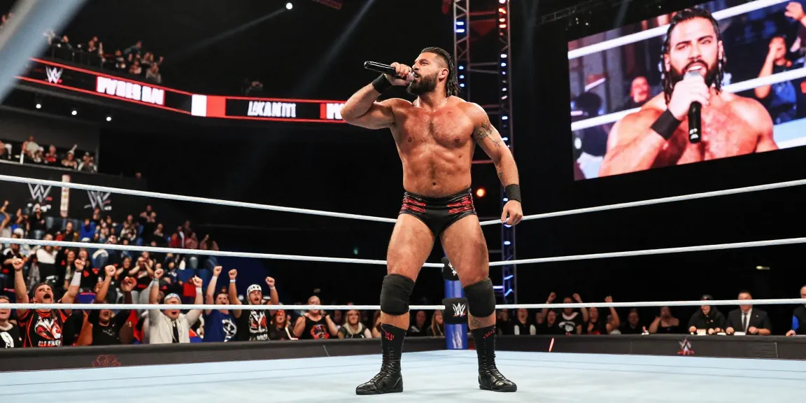 LA Knight captivating the audience during a WWE event with vibrant arena lights and excitement.